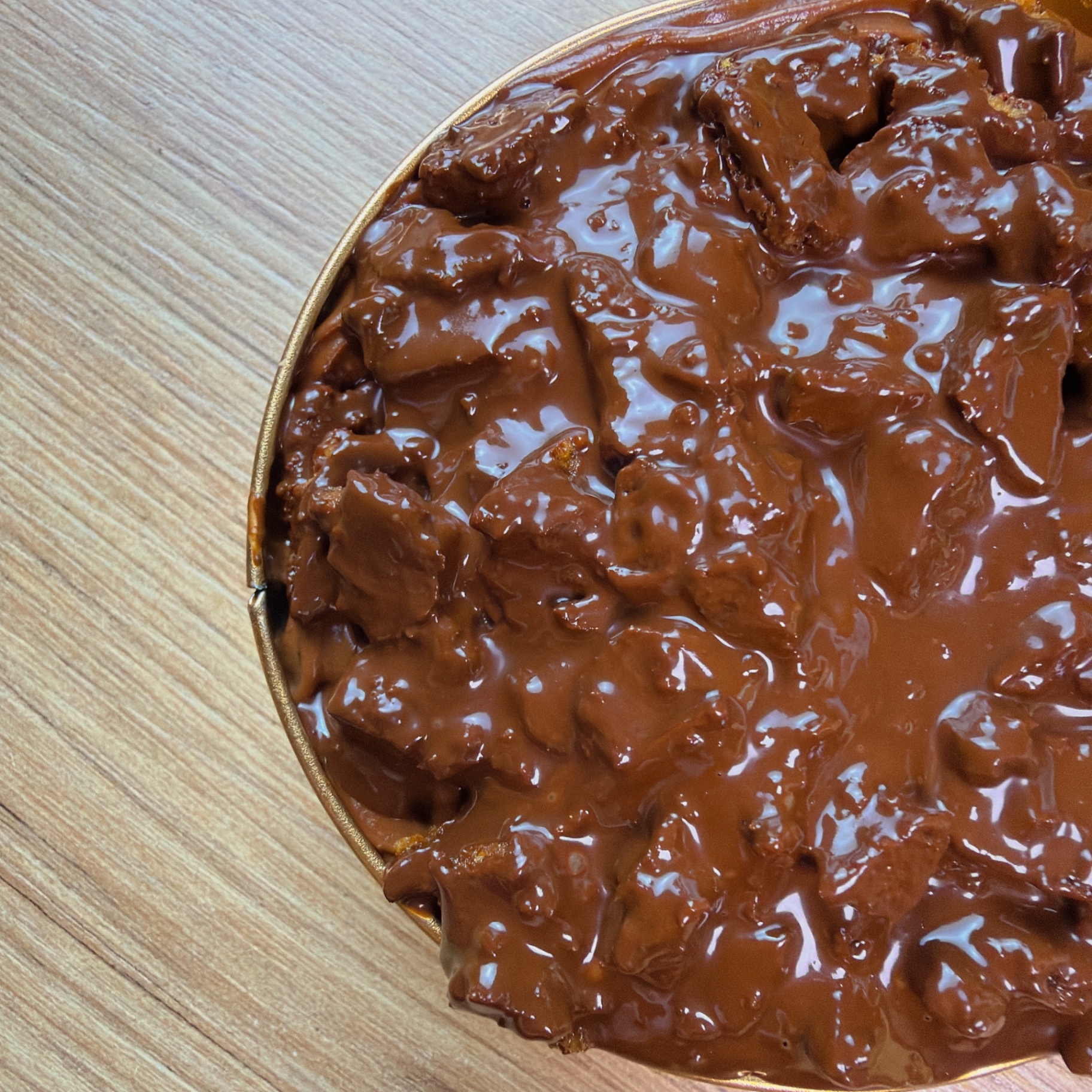 Crunch Cake Keto de chocolate visto desde arriba, cubierto de chocolate y trozos crocantes